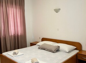 A single bed with a white mattress, two pillows, and a bedside table with a lamp. - Apartments Adriana Studio Apartment 6 (Gradac)