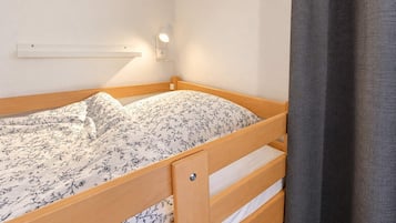 A single bed with a wooden frame and a floral-patterned bedspread.