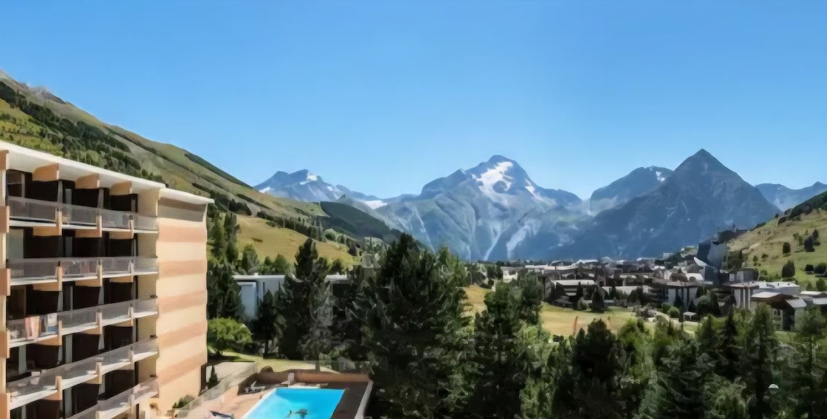 Un hôtel à plusieurs étages, doté d’une piscine et offrant une vue sur les montagnes.
