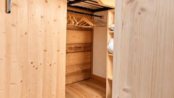 Un placard en bois avec une tringle pour suspendre les vêtements et une étagère.
