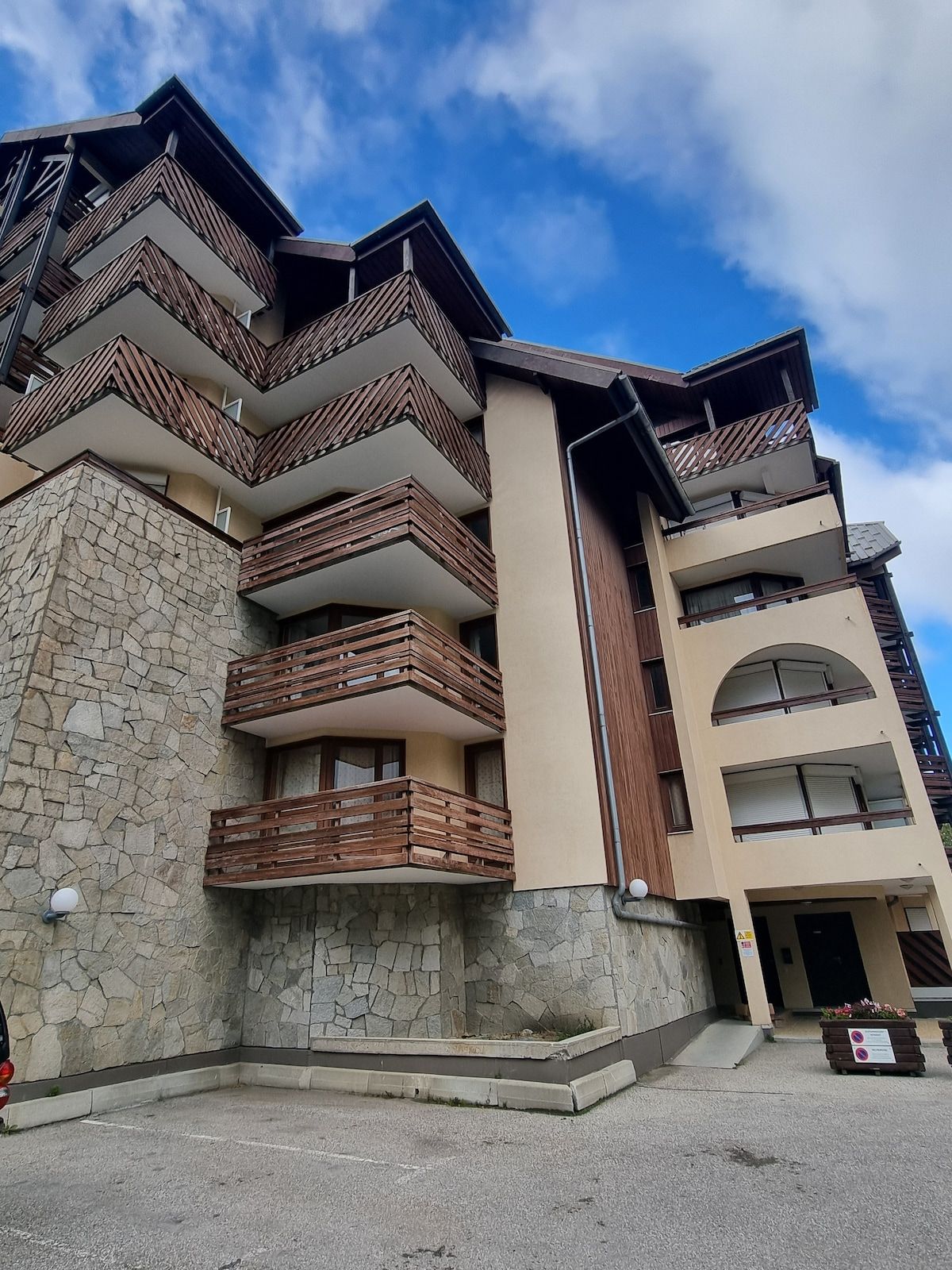 Ein mehrstöckiges Gebäude mit Balkonen, einer Stein-Fassade und blauem Himmel.