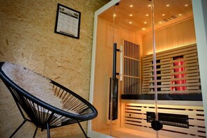 A room with a glass partition, a chair, and a wooden panel wall with red lighting. - Treehouse Getaway with Sauna (Oignies-en-Thierache)