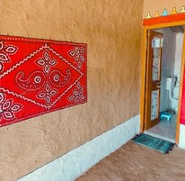 Una habitación con un tapiz decorativo en la pared, una puerta de madera y un pequeño escalón que lleva a un inodoro.