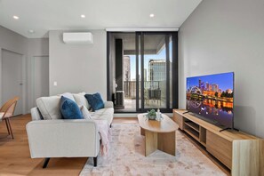 A modern living room with a sofa, coffee table, and a flat-screen TV. - City-View 2-Bed Apartment Near South Melbourne (South Melbourne)