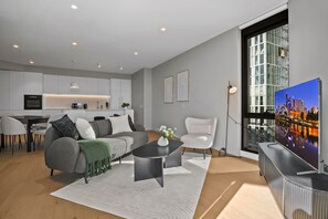 Ein modernes Wohnzimmer mit einer Couch, einem Couchtisch und einem Fernseher.