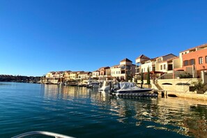 A marina with boats docked, waterfront buildings, and a clear blue sky. - Spacious 5-Bed Stay Near Mandurah (Wannanup)