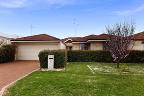 A residential property with a well-maintained lawn, a mailbox, and a clear sky. - Spacious 4-Bed House Near Mandurah (Dudley Park)