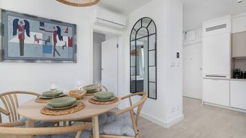 Un comedor con una mesa redonda, sillas y un cuadro en la pared.