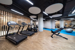 A gym with treadmills, a bench, and exercise balls. - Wave Apartments by Solarento (Międzyzdroje)