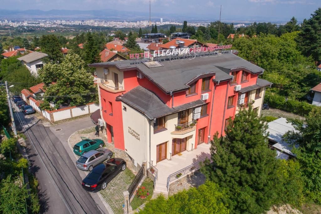 Un immeuble à plusieurs étages, doté d’une façade rouge et d’un balcon au deuxième étage.