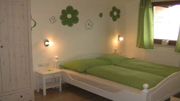 A bedroom with a bed, bedside table, and wall decorations.