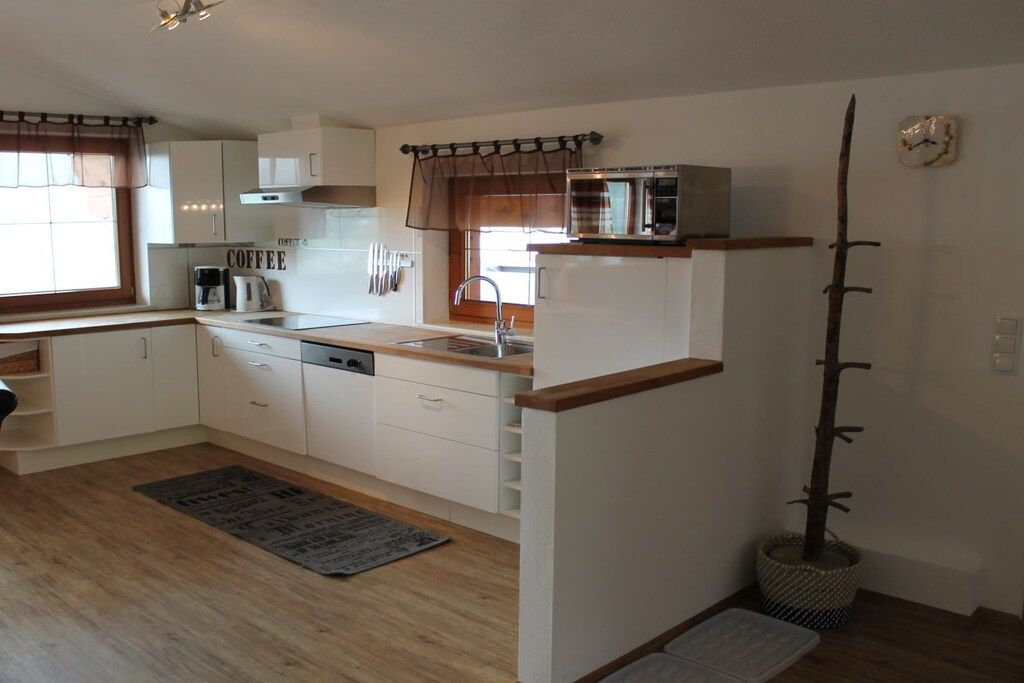 A compact kitchen with white cabinets, a microwave, and a coffee maker.