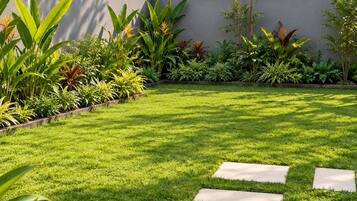 Un jardin bien entretenu, avec un chemin bien défini, une pelouse verdoyante et luxuriante, et diverses plantes.
