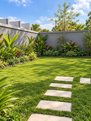 Un jardin bien entretenu, avec un chemin bien défini, une pelouse verdoyante et luxuriante, et diverses plantes.