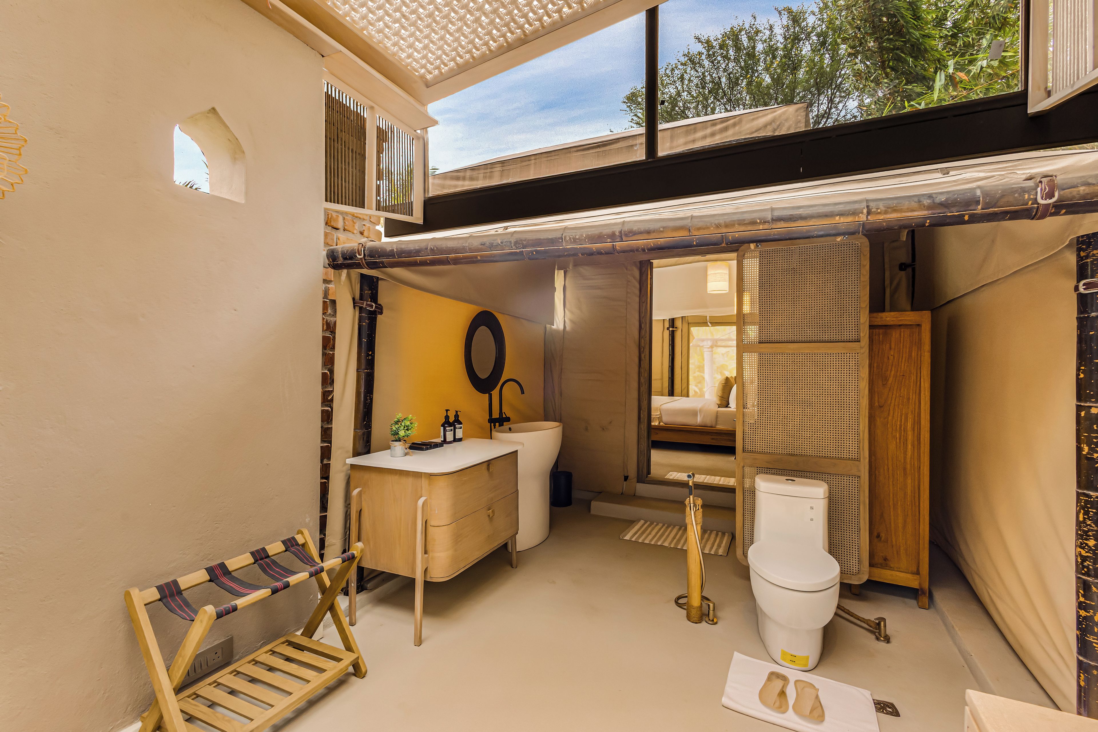 A compact bathroom with a sink, toilet, and a mirror.