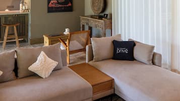 Una sala de estar moderna con un sofá modular, una mesa de centro y un comedor con una silla y una mesa.