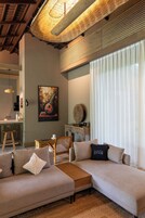 Una sala de estar moderna con un sofá modular, una mesa de centro y un comedor con una silla y una mesa.
