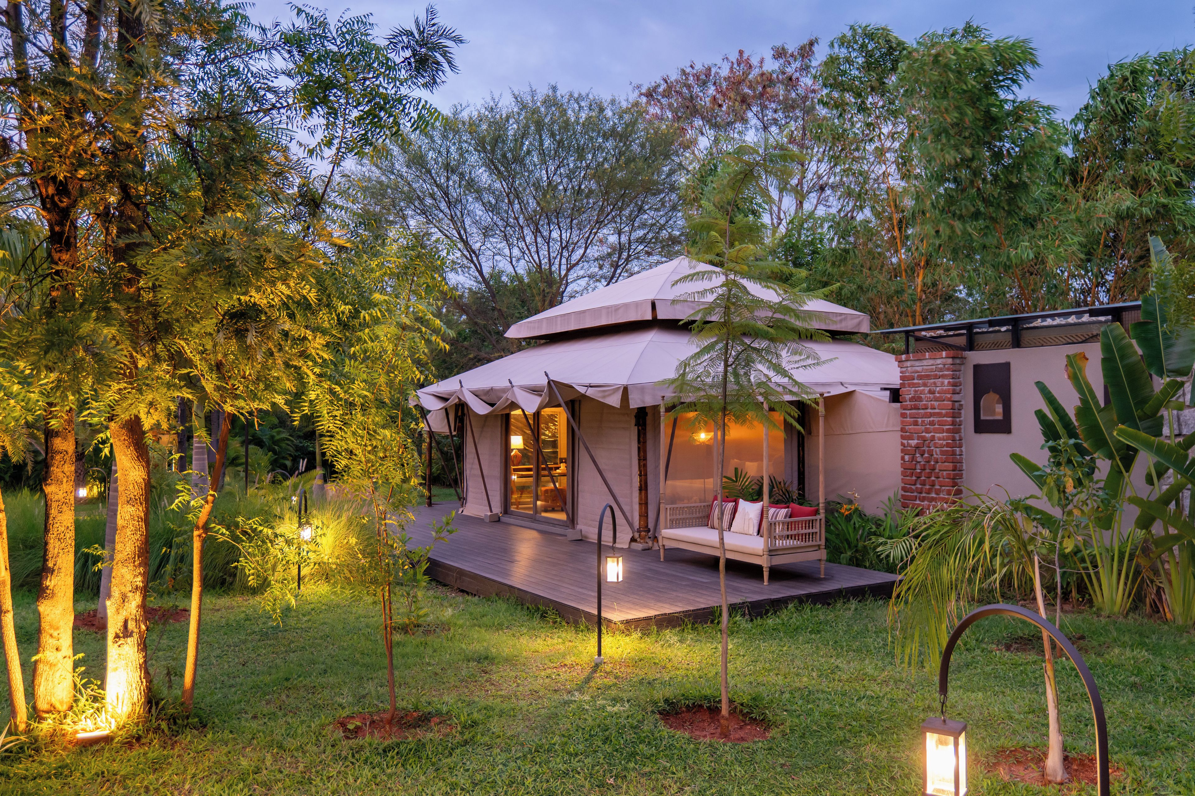 A cozy outdoor accommodation with a covered seating area, a small porch, and a well-maintained garden.