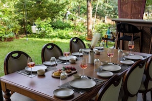 Une table à manger dressée pour six personnes, avec assiettes, verres et couverts.