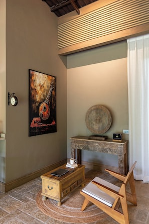 Une pièce comprenant un bureau en bois, une horloge murale, un tableau encadré et une assiette décorative ronde.