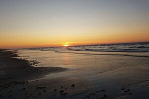 A beach at sunset with waves and footprints on the sand. - Holiday apartment with 1 bedroom (Nes Ameland)
