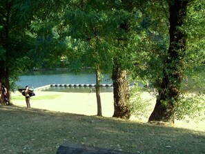 Ein Park mit einem See, Bäumen und einer Rasenfläche.