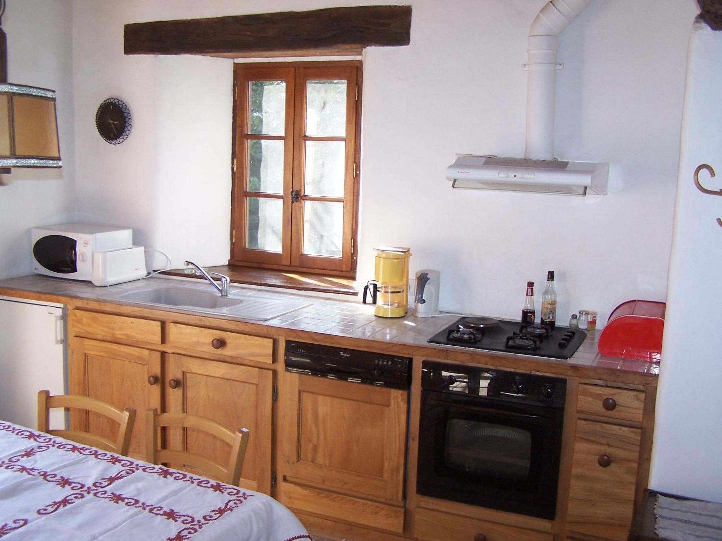 Une cuisine compacte équipée d’un évier, d’une cuisinière et d’un four à micro-ondes.