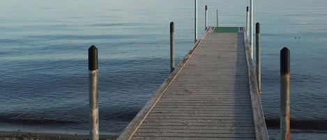 Un muelle de madera que se adentra en aguas tranquilas bajo un cielo despejado.