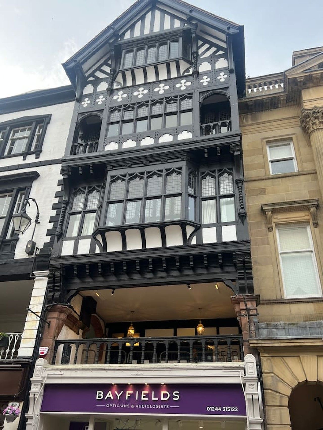 A building with a traditional architectural style, featuring a prominent bay window and a balcony with a railing.