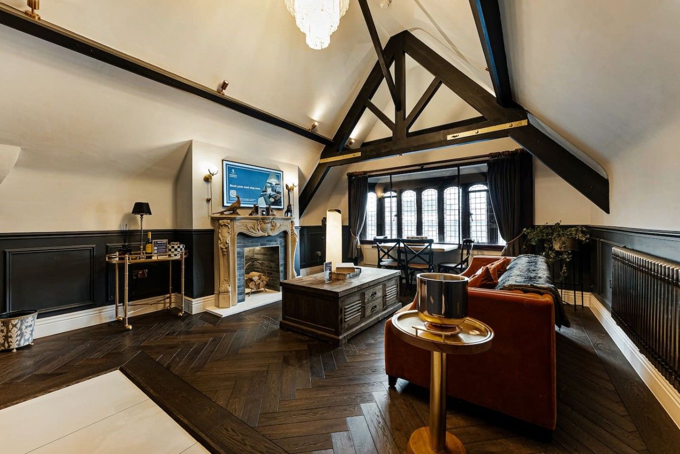 Une pièce spacieuse avec une cheminée, un canapé, une table et une fenêtre avec des rideaux.
