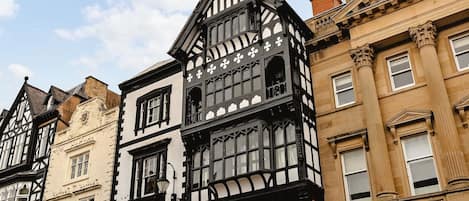A row of traditional half-timbered buildings with multiple stories and large windows.