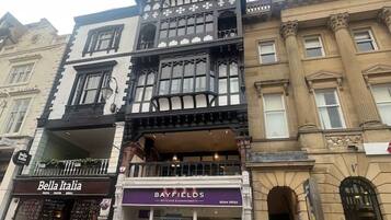 A multi-story building with a ground-floor shop named 'Bella Italia' and a second-floor shop called 'Bayfields.'