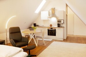 A compact, modern apartment with a kitchenette, a dining area, and a sleeping area. - Room 'Haus Salinen Loft 5' with Balcony, Wi-Fi and Air Conditioning (Bad Rothenfelde)