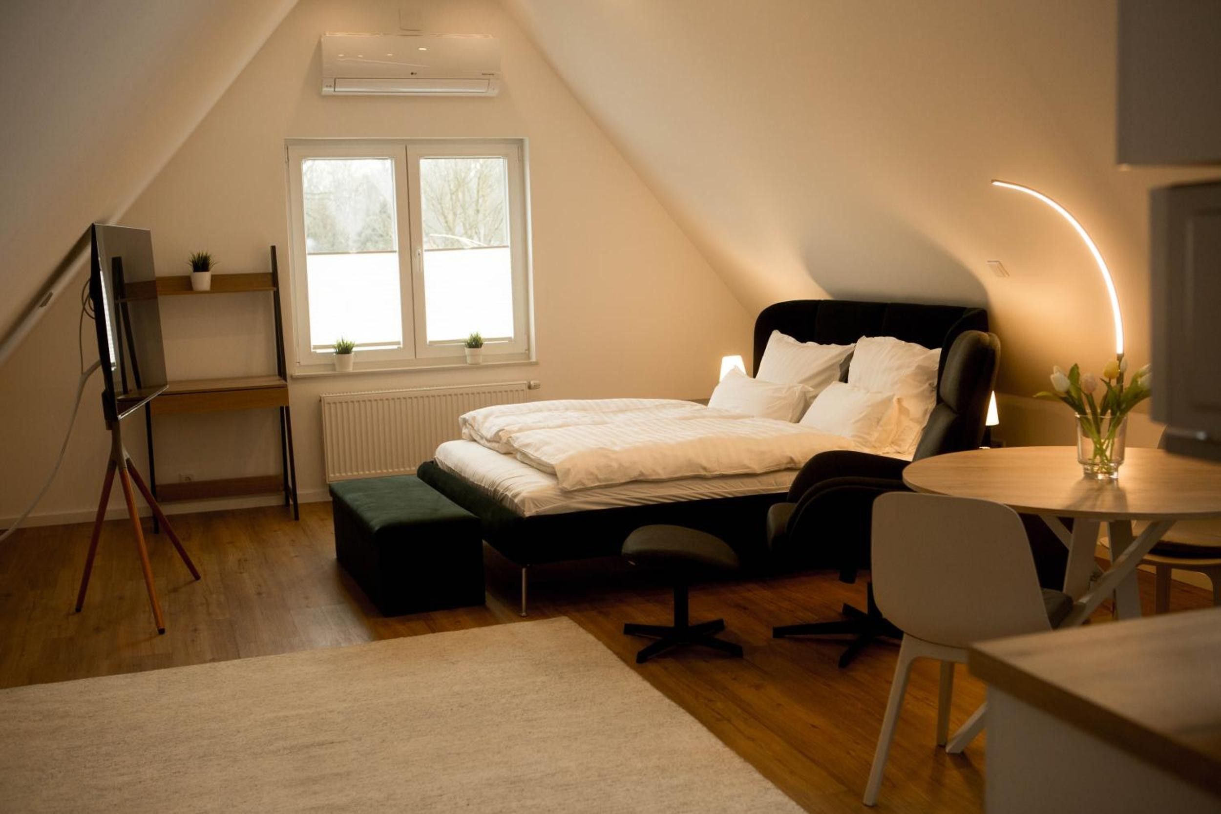 Ein modernes Schlafzimmer mit Bett, Nachttisch und Schreibtisch mit Stuhl.