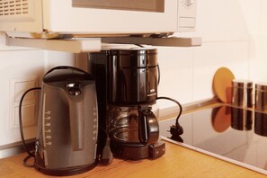 Una cafetera i un bllender a la superfície de la cuina.