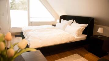 Ein Schlafzimmer mit Bett, Nachttisch, Lampe und Fenster.