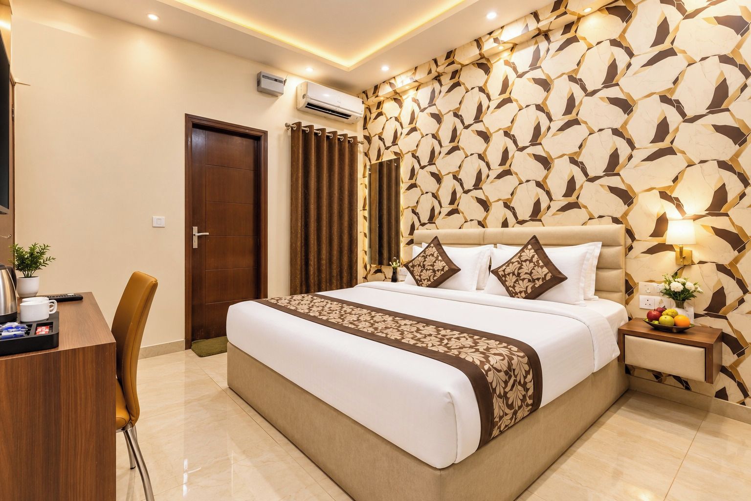 Habitación de hotel con cama, mesita de noche, lámpara y escritorio con silla.
