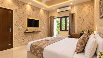 A hotel room with a bed, a TV, a window with curtains, a ceiling fan, and an air conditioning unit.