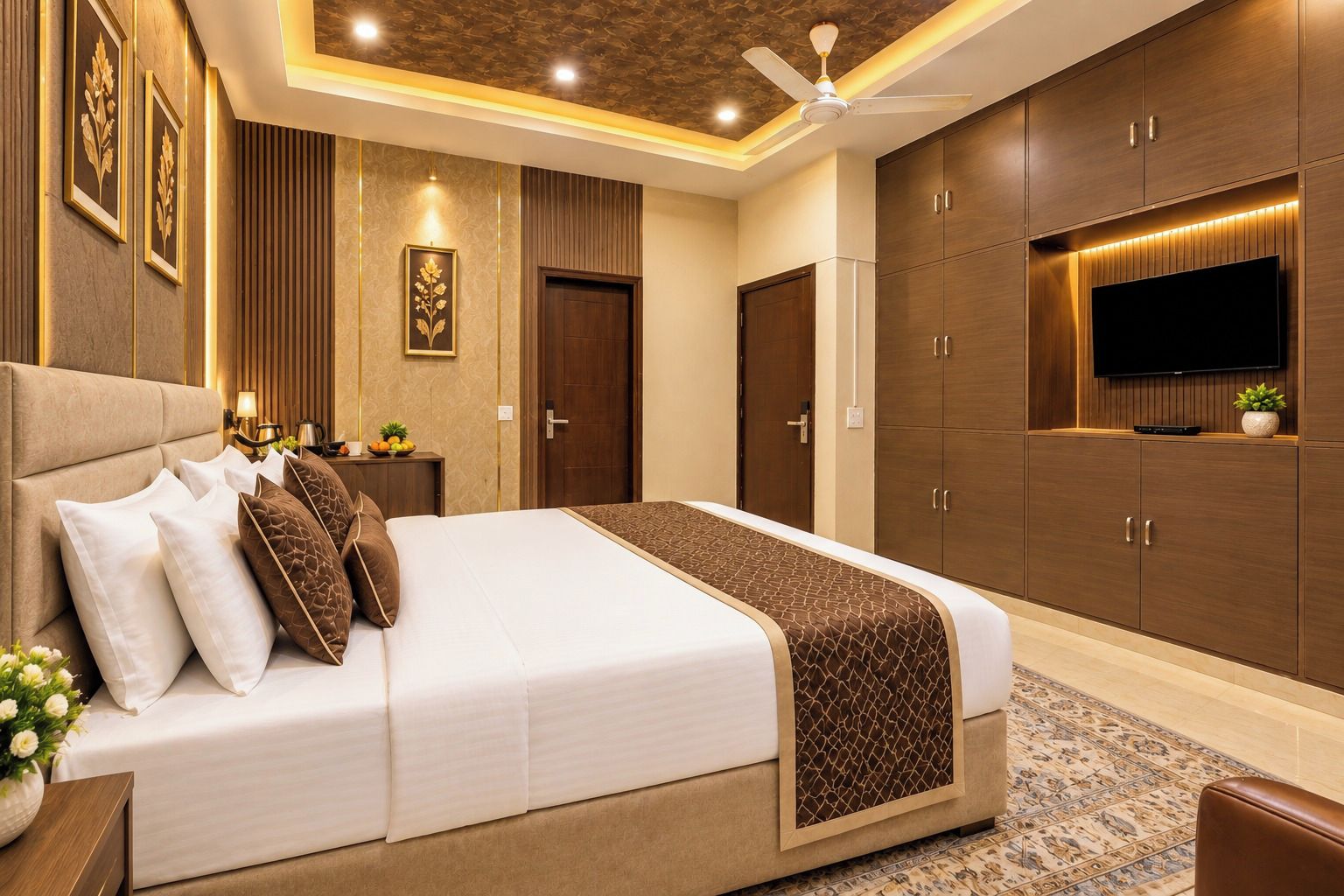 A modern hotel room with a large bed, a flat-screen TV, and built-in wardrobes.