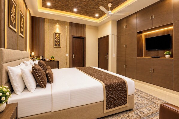 A modern hotel room with a large bed, a flat-screen TV, and built-in wardrobes.