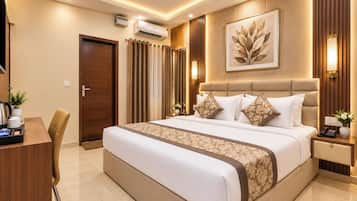 Quarto de hotel com cama grande, mesas de cabeceira, escrivaninha e uma cadeira.