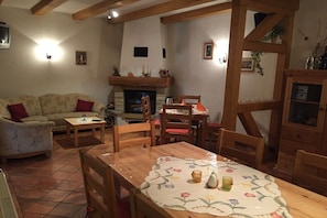 Ein gemütliches Wohnzimmer mit Kamin, Holzmöbeln und Fliesenboden.