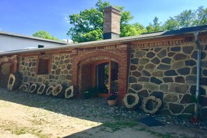 A stone building with a brick archway and a chimney. - Holiday apartment with 1 bedroom (Bastorf (OT Kägsdorf))