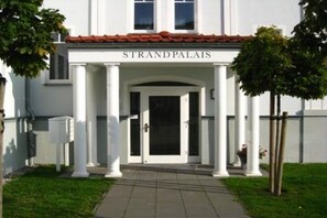 A building with a sign reading 'STRAND PALAIAS' and a covered entrance with columns. - Strandpalais Kühlungsborn "Starboard" (Kühlungsborn)