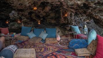 Un interior acogedor que recuerda a una cueva, con asientos, cojines y velas.