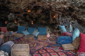 Un interior acogedor que recuerda a una cueva, con asientos, cojines y velas.