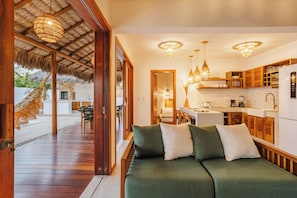 Una cocina moderna con armarios de madera, un comedor con mesa y sillas, y una zona de estar acogedora con un sofá.