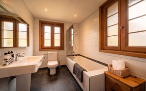 A bathroom with a sink, toilet, bathtub, and a shower area. - Chalet Béziere, Central Morzine – 5 Bed, Sleeps 15, Hot Tub, Garden & Fireplace (Morzine)