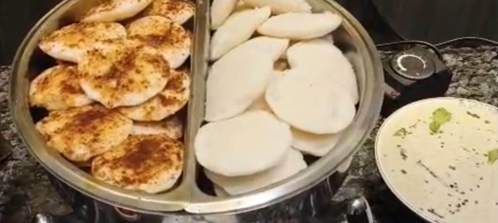 Una encimera de cocina con una bandeja metálica que contiene papas en rodajas y un tazón de salsa.