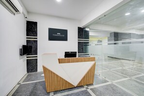A reception desk with a black sign that reads 'OYO TOWNHOUSE'. - OYO VIBEHAUS (Hyderabad)